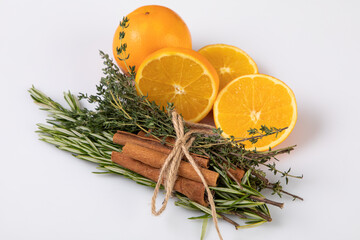 Bundle with herbs tied to cinnamon sticks and sliced orange  