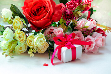 A postcard for Valentine's Day. Roses and a gift in red ribbon on a white background