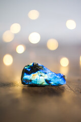 Labradorite on ancient wooden table, bokeh, hygge ambiance