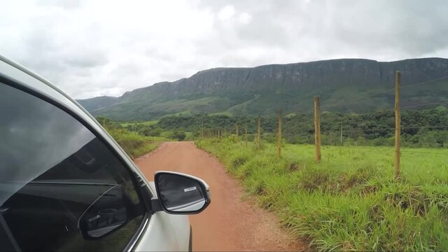 Driving a SUV car on a dirt road of the countryside. Dirt road next to Serra da Canastra, S&atilde;o Roque de Minas - MG, Brazil.