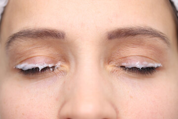 Moisturizer applied eyelid of female client beauty studio