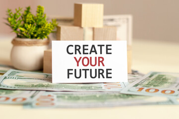 Paper card with text CREATE YOUR FUTURE. Wooden blocks, flowers and brown background