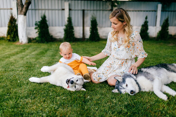 Mother and son posing with two dogs on the grass