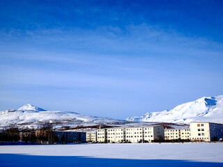 Mesmerizing view of beautiful snow-capped mountains with white buildings against a blue sky
