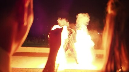 Fire show at the festival. The audience is happy. They dance and jump with pleasure.