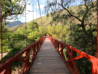 Obraz premium A wooden bridge across the river on the way to the archaeological site of Kotosh near the Peruvian city of Huanuco