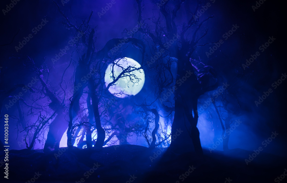 Wall mural spooky dark landscape showing silhouettes of trees in the swamp on misty night. night mysterious lan