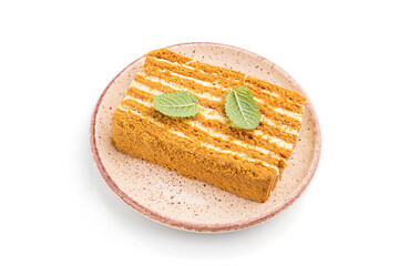 Homemade honey cake with milk cream and mint isolated on white background. Side view.