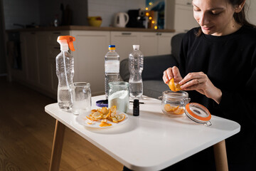 Millennial girl doing diy cleaning spray at home with vinegar, soda and lemon. Zero waste...