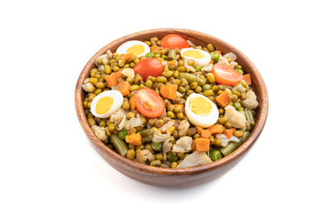 Mung bean porridge with quail eggs, tomatoes and vegetables isolated on white background. Side view.