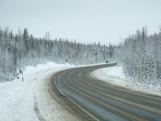 An empty, dirty winter highway. A turn on a slippery road.