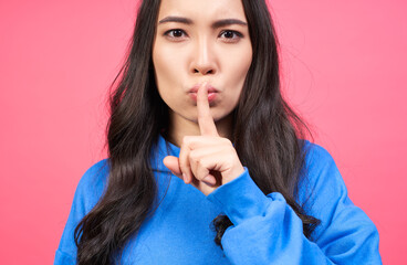 Fototapeta premium Close-up, a young Asian woman pressed her finger to her lips.