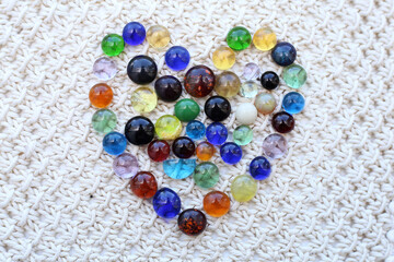Heart made of many small pieces of colored glass on the surface of the cloth.