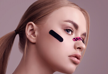 Beautiful blonde girl with glamour plasters on her face
