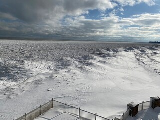 Snow and ice extend far out into Lake Michigan from the shoreline after multiple winter storms.