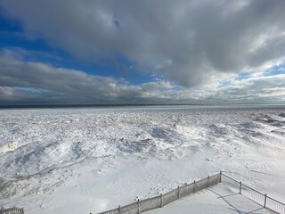 Snow and ice extend far out into Lake Michigan from the shoreline after multiple winter storms.
