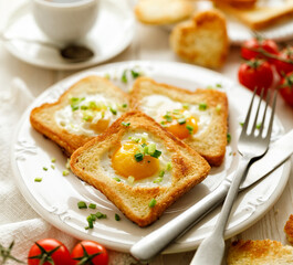 Valentine's breakfast, toast with a fried egg in the shape of a heart on a white plate, close-up.