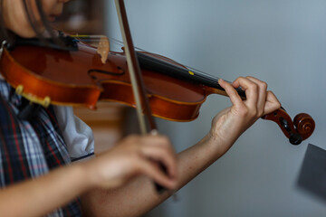 Close up on hands of girl in uniform playing violin. 