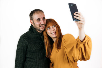 Happy couple taking a selfie together on white background