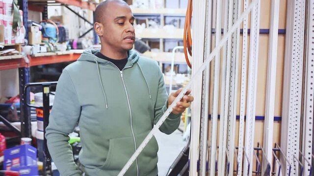 Man buys plastic corners for repair in a hardware store