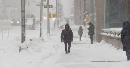 People walking street in winter snow storm blizzard in New York City on February 1st 2021