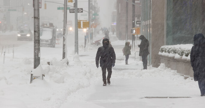 People walking street in winter snow storm blizzard in New York City on February 1st 2021 - Powered by Adobe