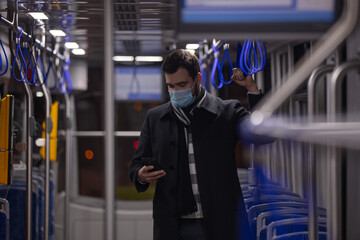 lonely guy in a face mask rides a tram at night in Pandemic time, Poland