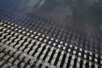 Fototapeta premium Top view, close-up detail of concrete graded access to the water or slope retaining concrete into water. 