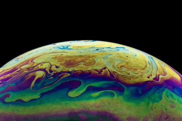 Close up, macro shot of a rainbow, multi colored soap bubble with yellow, purple, pink, blue and...