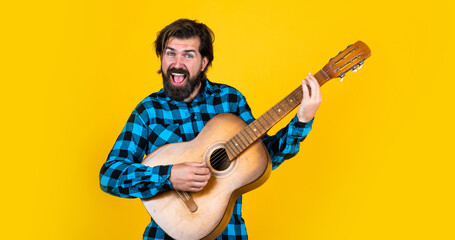 mature guitarist playing the guitar on yellow background, vocal