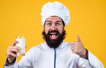 happy chef hipster in hat with beard and moustache on yellow background, useful milk