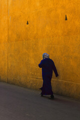 Arab woman in hijab walking alone on street