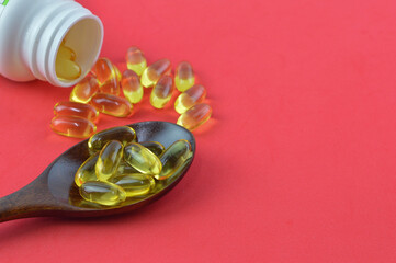 Pile of pills or capsules isolated on a red background. Drugs and medical concept.