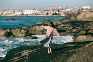 A woman is engaged in dances on the Alantic coast.