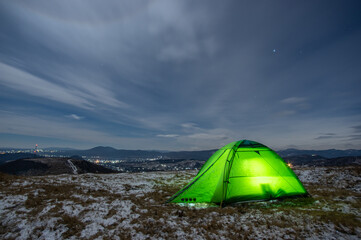 Tent in winter on top of the mountain at night