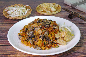 O Tao is a unique stir-fried dish made with Yam Oyster Omelettes mixed with battered taro, eggs, minced pork, garlic and spicy sauce, found only in Phuket Thailand. Phuket local street good