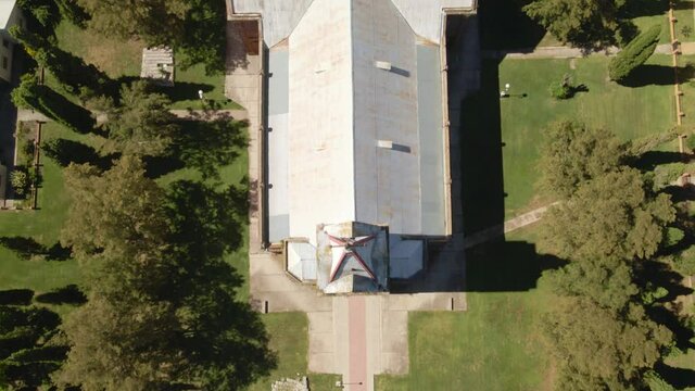 Aerial top down dolly in of an idyllic romantic style church surrounded by trees, Santa Anita, Entre Rios, Argentina