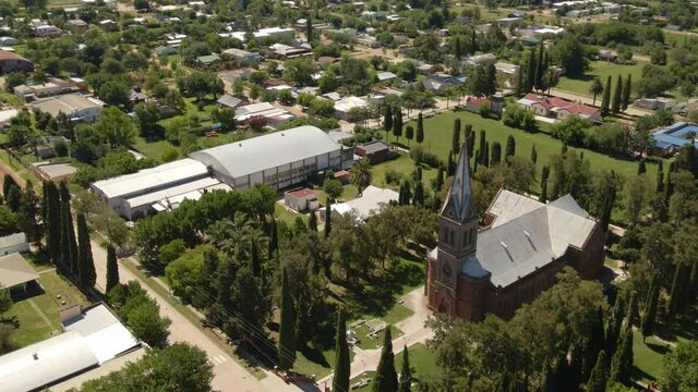 Orbital parallax of romantic style church surrounded by trees with Santa Anita little town in background, Entre Rios, Argentina