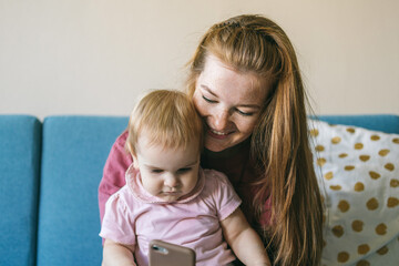 Mother and baby use the smartphone together. When to introduce your child to gadgets? Apps for kids