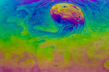 Close up macro, detailed shot of a soap bubble in professional, studio setting with black background behind. Stunning rainbow, colors with purple, green, yellow, green blue stunning, pretty beautiful