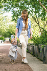 A young mother walks with a one-year-old baby. What to do while walking with your child