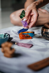 Yogi white woman holds a colored crystal. View of mixture of various colors glass triangular prism on wooden background. Selective focus