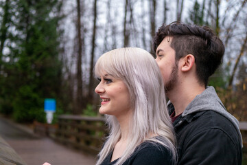 橋の上で男性が女性を抱きしめて景色を楽しむ