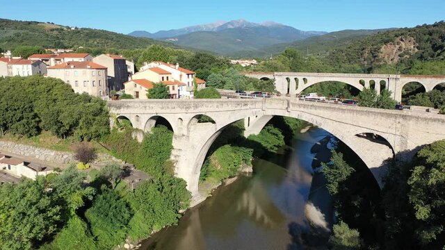 General view from drone of Ceret town on banks of river Tech in foothills of Pyrenees mountains in summer, France