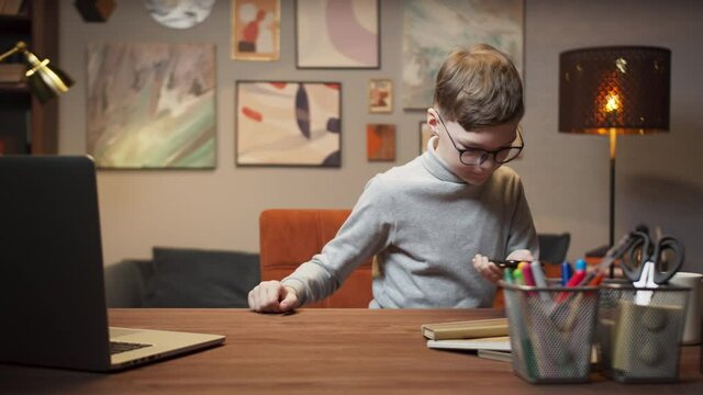 Kid boy using phone with AR 3D liar scan sensor, building mixed augmented reality model on table, student using vr technology on distance learning during lockdown, school remote learning.