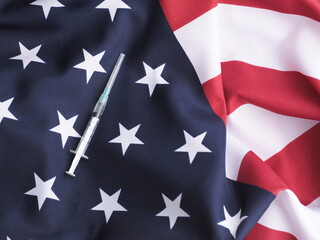 Fototapeta premium Syringe lies on flag USA. Coronavirus (COVID-19) Vaccine concept.