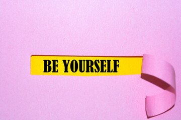 BE YOURSELF appearing behind torn paper. Business