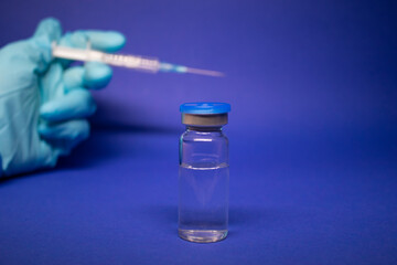 Development of coronavirus vaccine COVID-19. medical syringe with injection needle in blue medical...