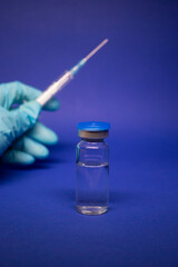 Development of coronavirus vaccine COVID-19. medical syringe with injection needle in blue medical...