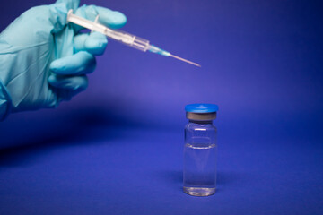 Development of coronavirus vaccine COVID-19. medical syringe with injection needle in blue medical...